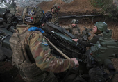 Servicemen fire a howitzer towards Russian troops at a position on front line in Donetsk region