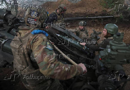 Servicemen fire a howitzer towards Russian troops at a position on front line in Donetsk region