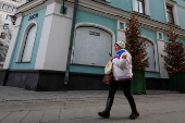 FILE PHOTO: A woman walks past a closed Dior store in Moscow