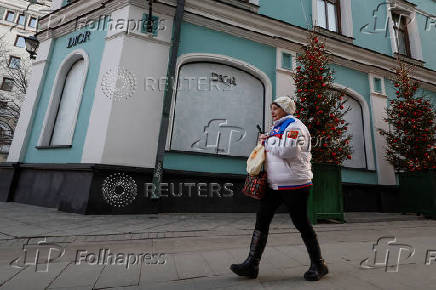 FILE PHOTO: A woman walks past a closed Dior store in Moscow