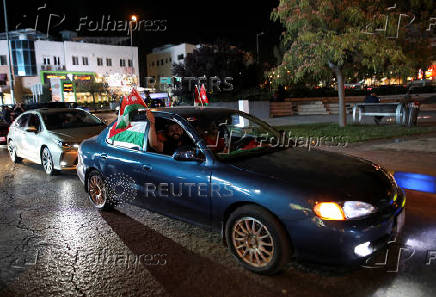 Jordanians celebrate after Jordan qualified for the World Cup for the first time, winning 3-0 over Oman, in Amman