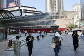 People walk in front of the new Louis Vuitton store in Shanghai