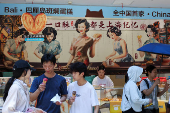 People hold ice creams amid a yellow alert for heat, in Shanghai