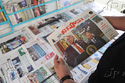 A man holds a newspaper with a cover photo of U.S. President Donald Trump and U.S. Middle East envoy Steve Witkoff, in Tehran
