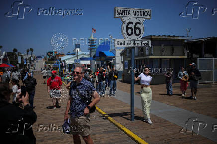 Visitors pose for pictures along the Santa Monica Pier in Santa Monica