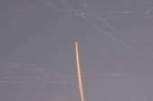 A military aircraft flies in the sky following a barrage of missiles launched from Iran, as seen over Tubas