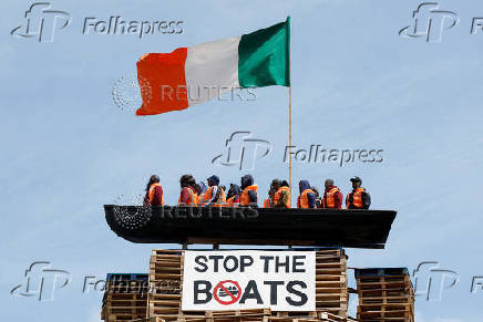 Bonfire pyre with effigy of migrants in a boat atop it, in Moygashel