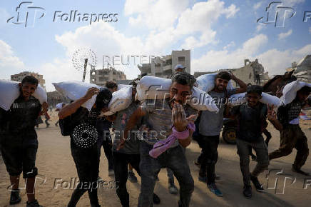 Palestinians gather to receive aid supplies amid a hunger crisis, in Beit Lahia
