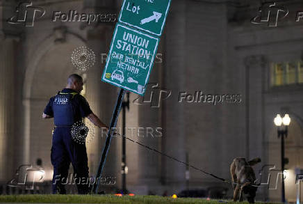 A police officer walks with a dog near the Union Station, in Washington