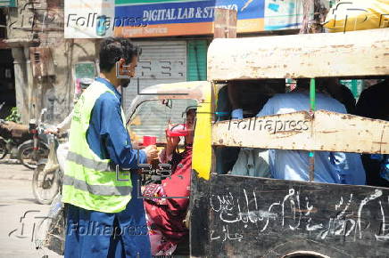 Volunteers distribute cold drinks on a roadside in Hyderabad