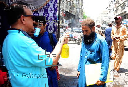 Volunteers distribute cold drinks on a roadside in Hyderabad