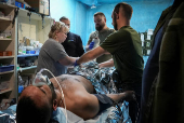 Medics help a wounded Ukrainian serviceman at a medical stabilisation point, near the town of Pokrovsk, in Donetsk region