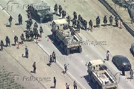 A military convoy enters the area during an immigration raid on an agricultural facility in Camarillo