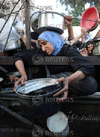 Palestinians wait to receive food from a charity kitchen, amid a hunger crisis, in Gaza City