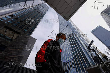 Delivery worker walks past buildings at Central Business District (CBD) in Beijing