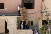 Palestinians carry their belongings after Israel's decision to demolish their homes in Nur Shams camp