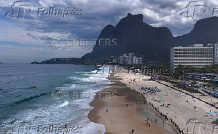 People attend a symbolic ritual named 'O Abraco' marking the World Oceans Day, at Sao Conrado beach in Rio de Janeiro