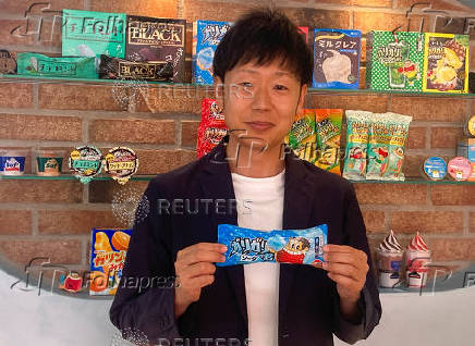 Akagi Nyugyo's marketing team leader Hideyuki Okamoto holds the company's flagship Garigari-kun candy bar at its headquarters in Saitama