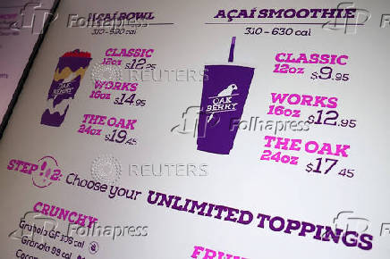 A sign displaying various Acai products is seen inside an Oakberry Acai bowl location in New York City