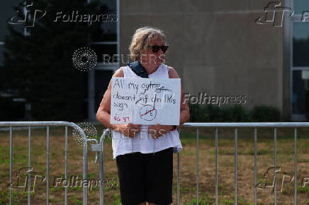 Mary Charters holds a sign during a rally concerning the escalating local immigration enforcement actions in the Long Island area outside the Suffolk County Center in Riverhead, New York