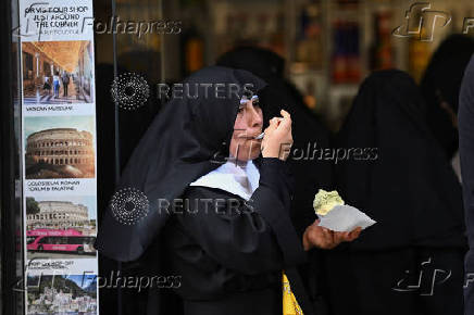 Members of media sit at a cafe, in Rome
