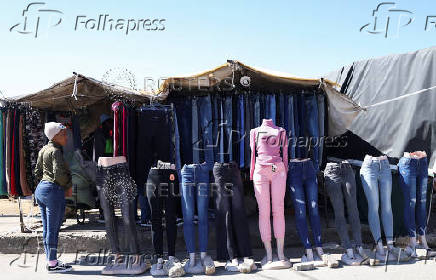 A women stands next to a makeshift stall selling jeans in Maseru