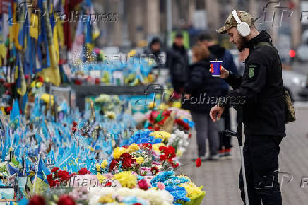 Person in military uniform stands in front of the makeshift memorial to fallen Ukrainian defenders at Independence Square in Kyiv