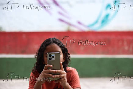 Aluno de escola municipal do bairro Cidade Patriarca, em São Paulo, usa celular