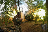 A Ukrainian serviceman fires a howitzer towards Russian troops at a front line in Zaporizhzhia region