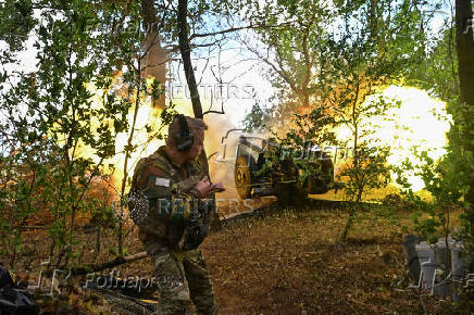 A Ukrainian serviceman fires a howitzer towards Russian troops at a front line in Zaporizhzhia region