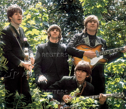 The Beatles walk and sing as they are filmed during a promotional video for their song ?Rain?, in a garden outside Chiswick House