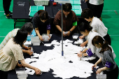 Election officials count votes at a ballot counting centre for Japan's upper house election in Tokyo