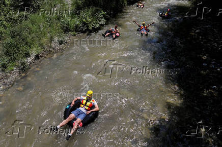 Sports enthusiasts compete while floating on inner tyre tubes during the tyre festival 'Bunar Fest' in Prizren