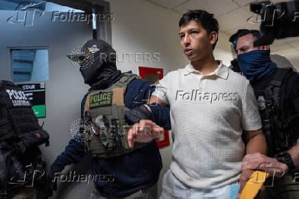 A migrant is detained by federal immigration officers at U.S. immigration court