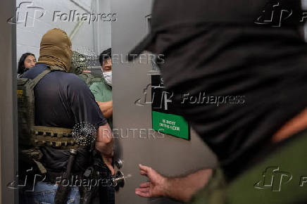A migrant is detained by federal immigration officers at U.S. immigration court