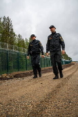 Finnish Border Guard at the barrier fence between Finland and Russia