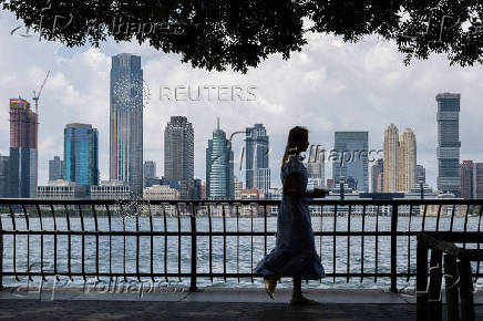 A woman walks along the Hudson River in New York