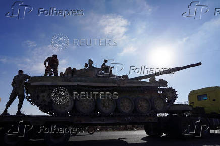 A member of the Syrian security forces stands on a military vehicle in Sweida