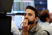 Traders work on the floor of the AMEX at the NYSE in New York