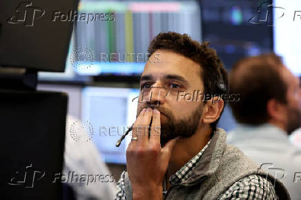 Traders work on the floor of the AMEX at the NYSE in New York