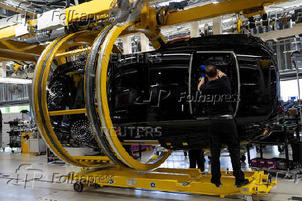 A technician works on the assembly line for Rolls-Royce Spectre vehicles at Rolls-Royce Motor Cars' manufacturing plant in Goodwood