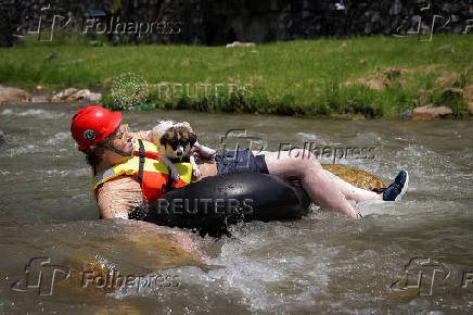 Sports enthusiasts compete while floating on inner tyre tubes during the tyre festival 'Bunar Fest' in Prizren