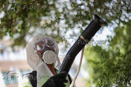 A worker sprays insecticide at a public housing estate following reports of imported cases of Chikungunya in Hong Kong