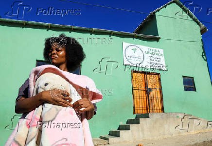 Athenkosi Sobuza stands with her two-months-old baby, Liselihle, outside the Fellowship Baptist Church, where U.S. pastor Josh Sullivan was kidnapped, in Gqeberha