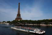 A tourist boat travels on the River Seine and the Eiffel Tower in Paris