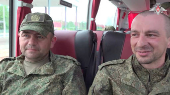 Russian soldiers sit a bus in Belarus after release from Ukraine on the third day of POW exchange