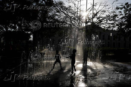 Children play at a fountain in San Salvador