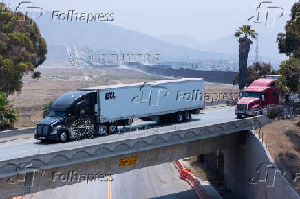 Trucks enter the United States from Mexico after clearing U.S. Customs in San Diego