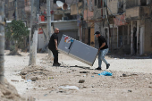Palestinians carry their belongings after Israel's decision to demolish their homes in Nur Shams camp