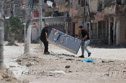 Palestinians carry their belongings after Israel's decision to demolish their homes in Nur Shams camp